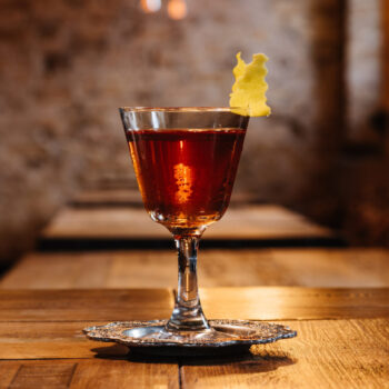 close-up view of sazerac cocktail in glass on wooden table