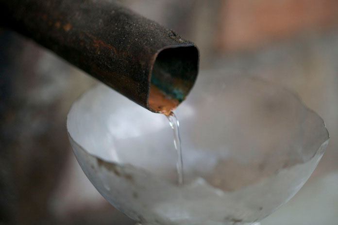 A pipe with clear liquid flowing out of it